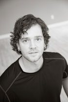 A man with curly hair and a black shirt