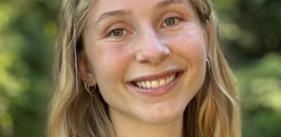 A young woman with long hair smiles for the camera.