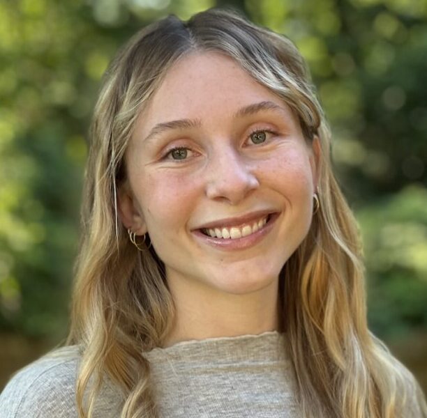 A young woman with long hair smiles for the camera.