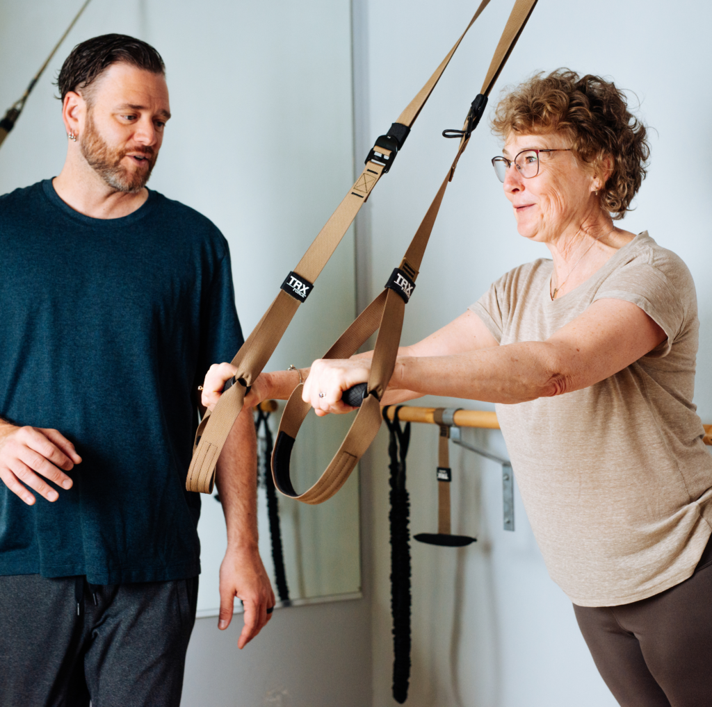 Adam works with a client on the TRX cables