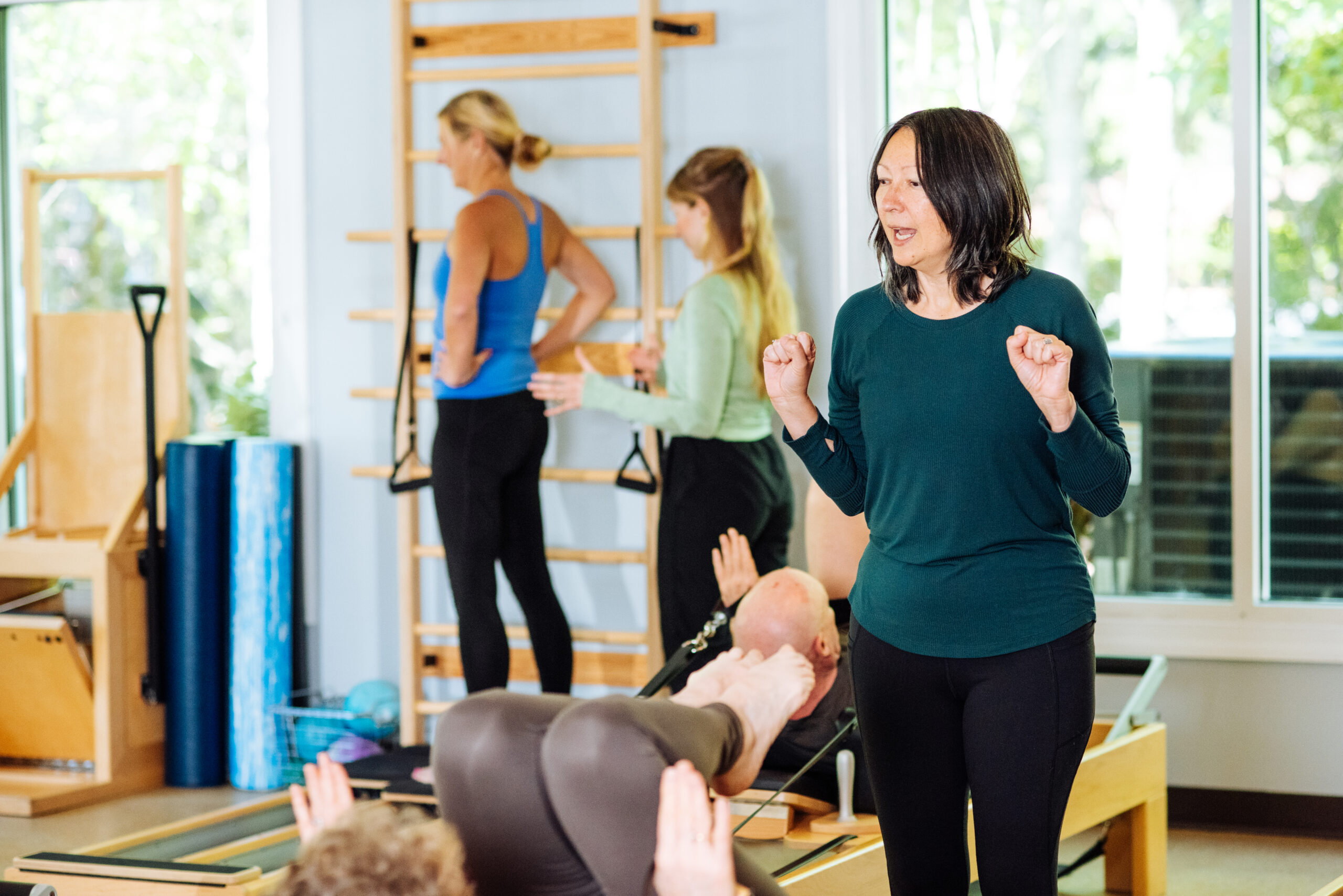 Two Pilates Instructors teach clients at InsideOut Body Therapies. They are a range of ages.