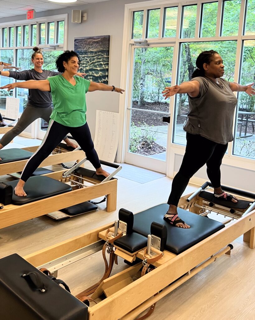 Three people work out on the Pilates Reformer Three people work out on the Pilates Reformer